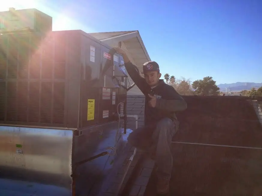 HVAC technician performing Boiler Repair on a rooftop unit in Wallingford